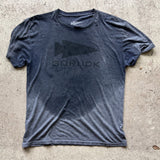 A dark gray Three Rules Tee - Unisex Tri-BlendX with wet spots, laid flat on concrete—a cool essential for those who never get lost.