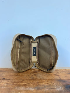GORUCK tan zippered pouch open with mesh pockets on wooden surface