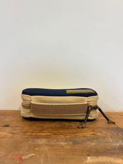 GORUCK tan and black tactical gear pouch with zippers, on wooden surface