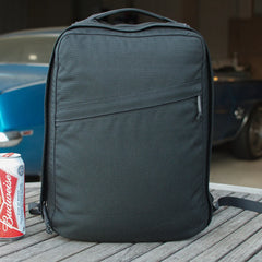 GORUCK black rucksack on wooden table with Budweiser can and blue car in background