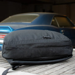 GORUCK black rucksack on wooden table with blue classic car in background