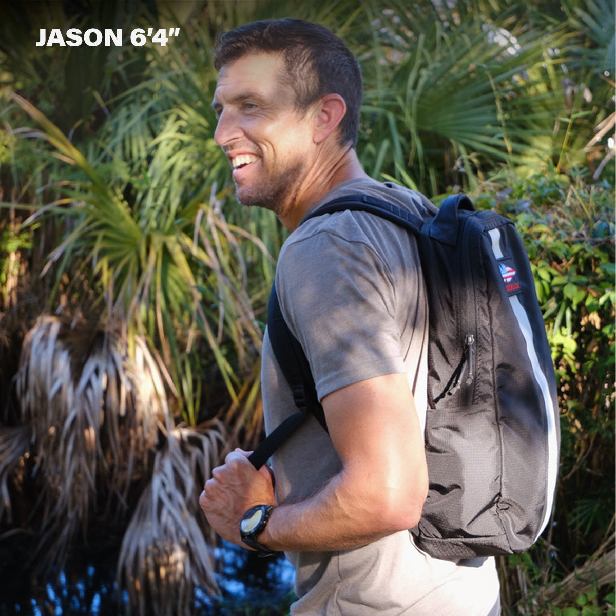 A man smiles outdoors, surrounded by greenery, wearing the Basic Rucker®; text reads "JASON 6'4"".