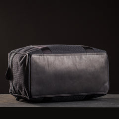 Black GORUCK kit bag with reinforced bottom panel on dark surface and black background