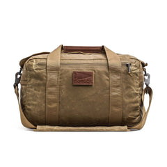 The Kit Bag - Waxed Canvas is a tan duffel inspired by classic aviator kit bags, featuring handles, a shoulder strap, and a leather front patch that reads "GORUCK.