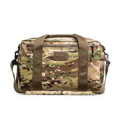 The Kit Bag - X-PAC, inspired by Special Forces gear, features camo print, olive green straps, and a shoulder strap. Shown against a white background.