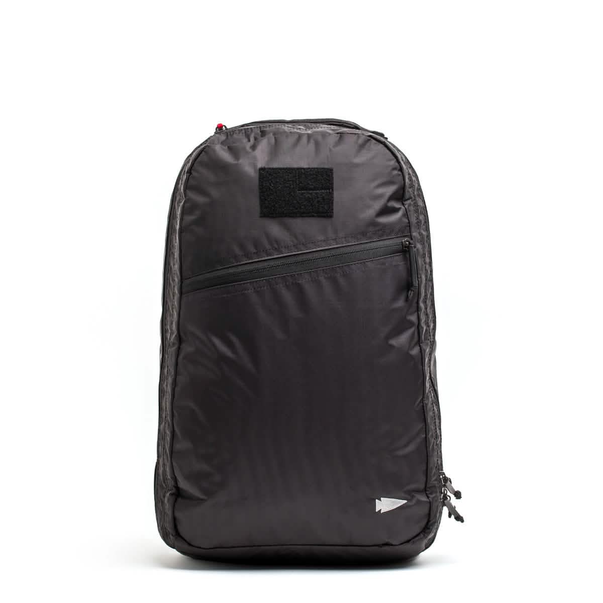 The GORUCK Bullet Ruck Double Compartment in black showcases a minimalist design with a front zippered pocket and a small square patch above it. Made from durable Dyneema, it features a subtle arrow emblem near the bottom right and comes with our Lifetime Guarantee for peace of mind.