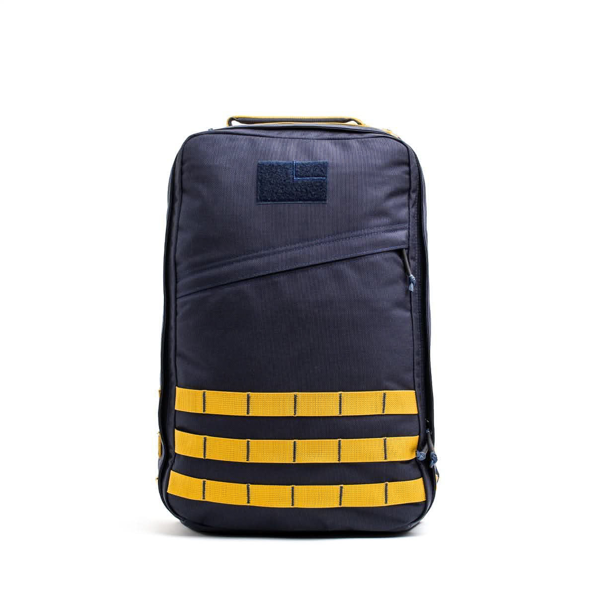 The GR1 USA - Cordura is a navy blue Special Forces backpack with yellow horizontal straps and a top handle, displayed on a white background.