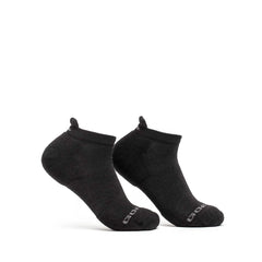 A pair of Merino Challenge Socks - Ankle by GORUCK, crafted in a soft black Merino wool, are showcased on a white background. They feature a small tag on the heel and a logo on the sole, proudly made in the USA.