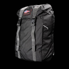 Black GORUCK rucksack with grey straps and American flag patch on top against black background