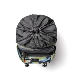 Top view of a GORUCK modern camouflage backpack with a drawstring closure crafted from durable Cordura materials. The interior features a mesh pocket and a zippered compartment, perfect for organization. This sleek M24 rucksack is laid flat against a white background, highlighting its stylish design.