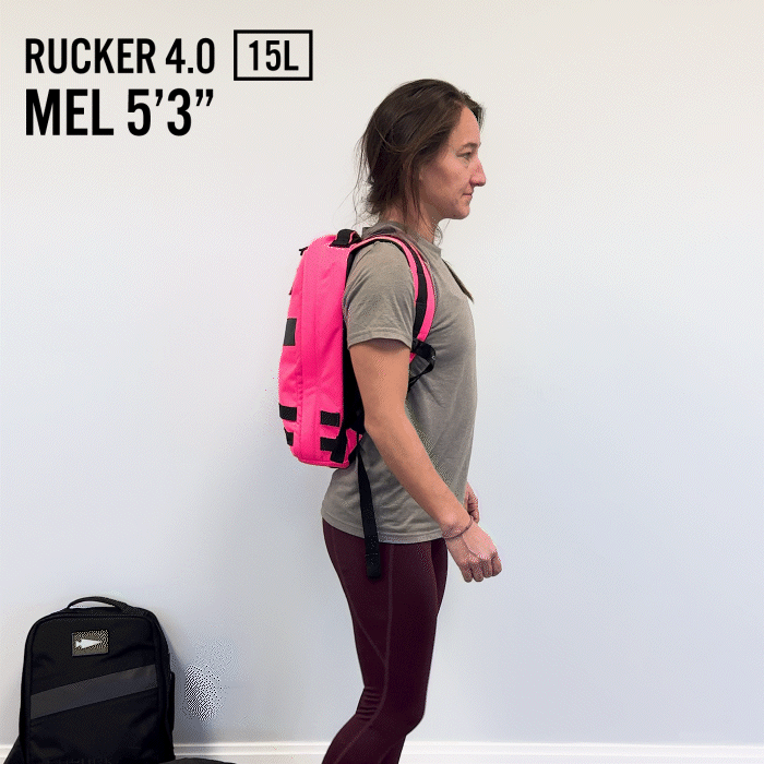 A woman wearing a pink backpack stands sideways, showcasing the Rucker 4.0, with 