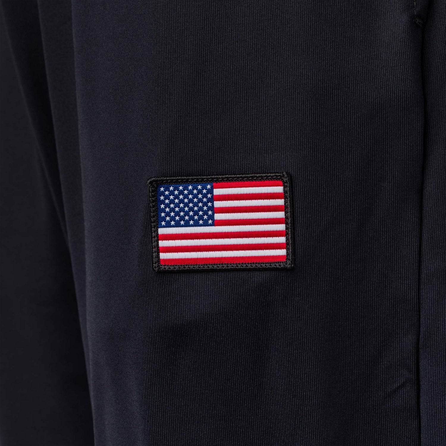 A small embroidered American flag patch decorates the dark performance fabric of the Men’s Training Performance Joggers, proudly made in the USA.