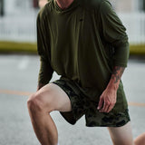 Man wearing GORUCK camo ranger panties and olive hoodie lunge exercising outdoors
