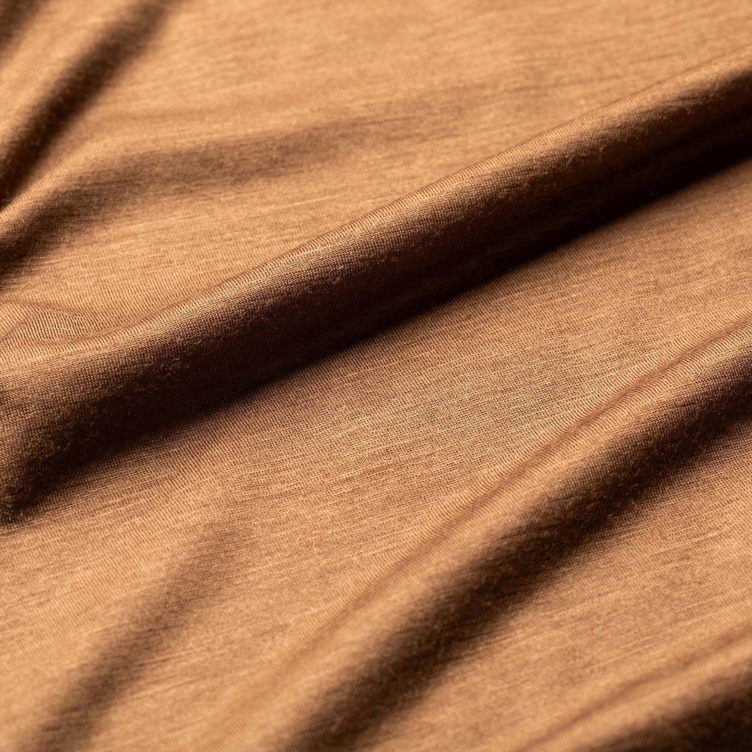 Close-up of the Men’s Commando Pullover in soft brown merino wool, showing gentle folds and a smooth, subtly textured surface.