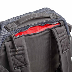 Close-up of the Mesh Ruck, a black quick-drying backpack featuring padded straps and a partially open zipper that reveals its red interior.