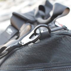 A close-up of a black carabiner clip attached to a mesh pocket on the Mesh Duffel Bag.