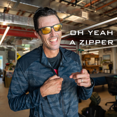Smiling man in sunglasses points to his jacket zipper; text reads "OH YEAH A ZIPPER." The Warm Up Full Zip features ToughDry shoulders and is proudly made in the USA.