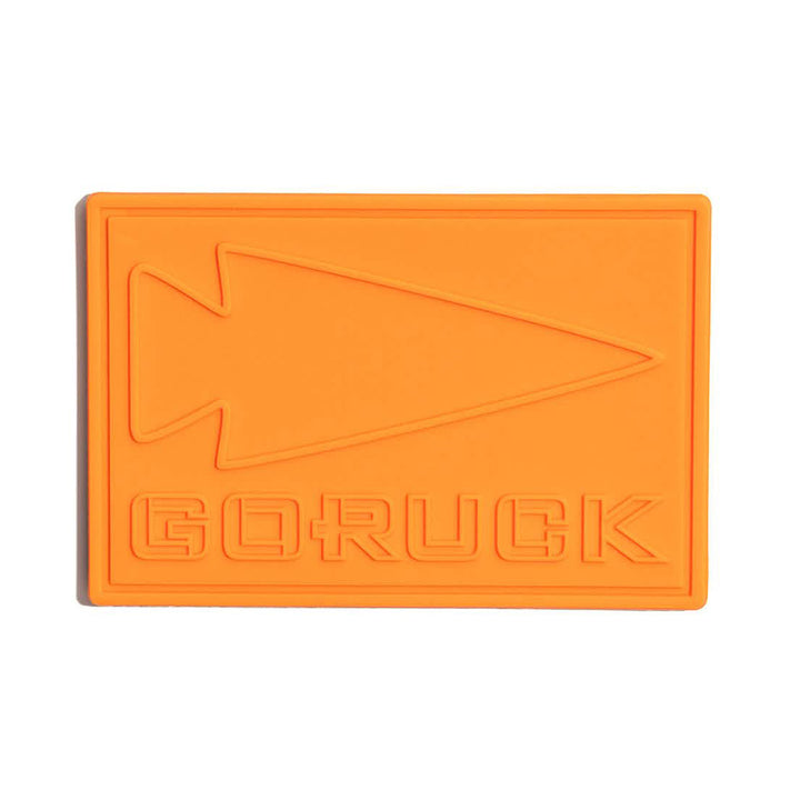 Orange PVC Patch - GORUCK is made from durable plastic with an arrowhead design and "GORUCK" embossed, inspired by Special Forces resilience.