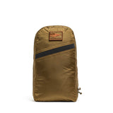 The Packable Bullet Ruck - Ripstop ROBIC® is a brown lightweight travel backpack featuring a diagonal black stripe and a rectangular GORUCK patch on the front.