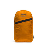 The Packable Bullet Ruck - Ripstop ROBIC® is a bright orange GORUCK lightweight travel backpack featuring a diagonal black stripe and logo patch, shown standing upright on a white background.
