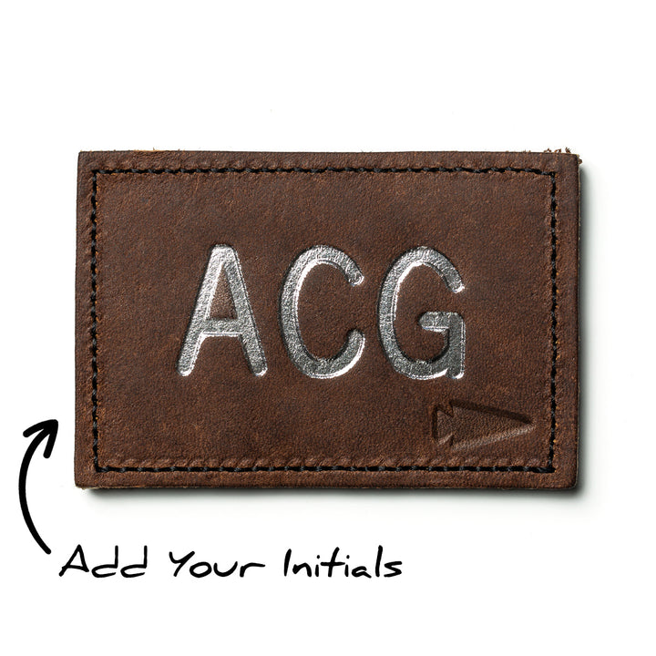 Personalize the Patch - Custom Leather Monogram: Brown leather with silver initials "ACG" and space for your customization. An arrow directs you to "Add Your Initials," making it a unique accessory.