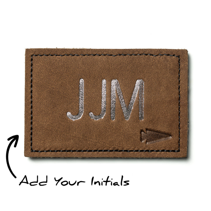 Custom leather monogram patch with silver initials "JJM" and arrow icon, personalized with "Add Your Initials" for customization.