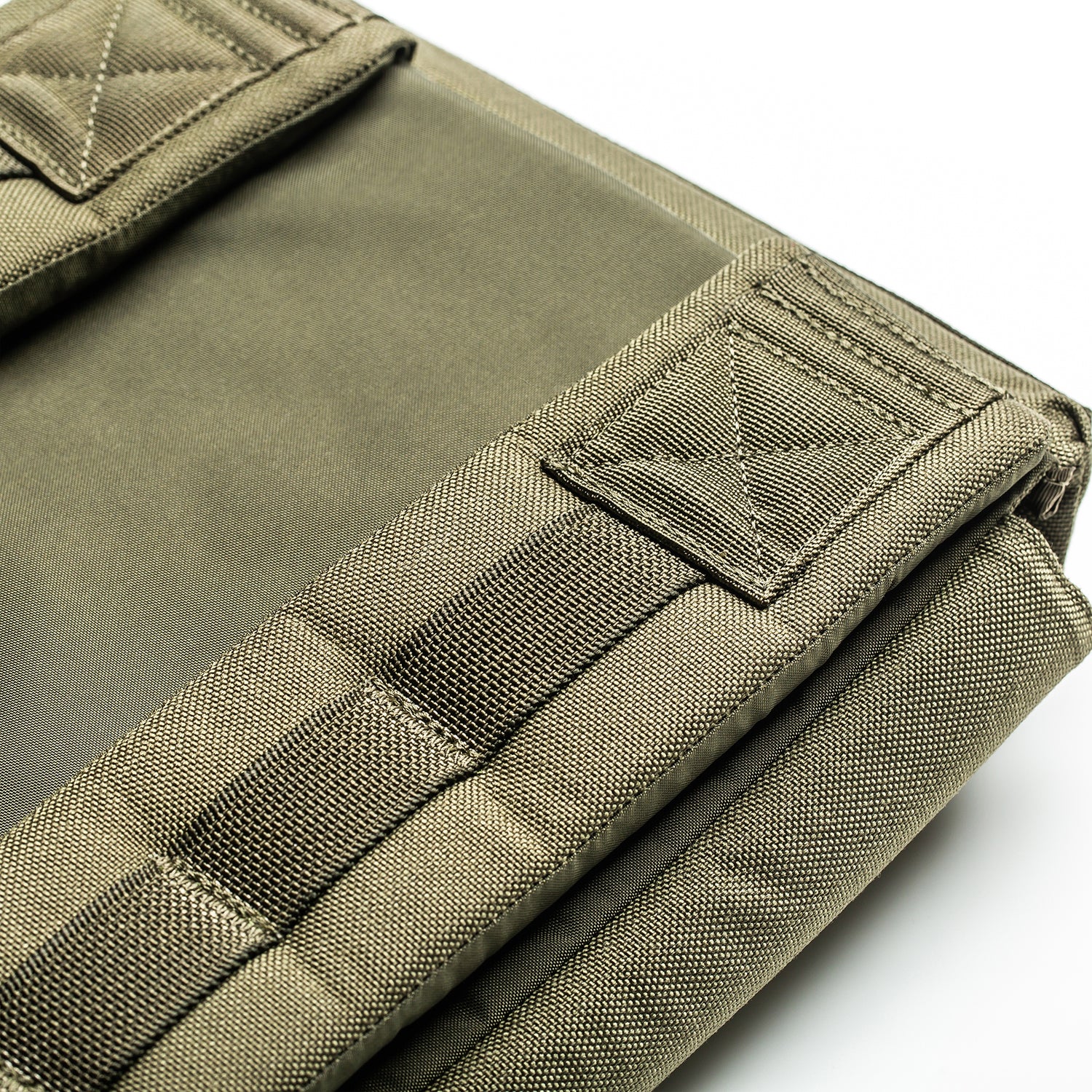 Close-up of the olive green RPC 3.0 backpack, made with reinforced stitching and heavy-duty fabric, shown folded and paired with a 10lb Ruck Sandplate—ideal for weighted training sessions.
