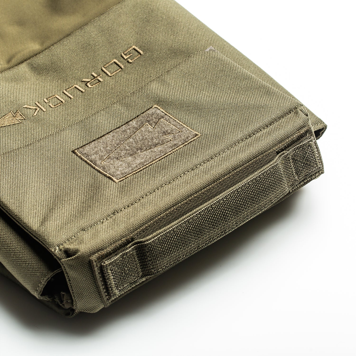 A close-up of the olive-green RPC 3.0 + 10lb Ruck Sandplate, featuring sturdy stitching, a Velcro patch, and dedicated space for the sandplate—ideal for weighted training or as a versatile Ruck Plate Carrier.