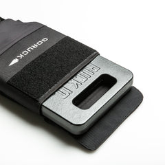 An RPC 3.0 + 10lb Ruck Sandplate is partially inserted into a black sleeve with a Velcro strap, designed for weighted training, set against a white background.
