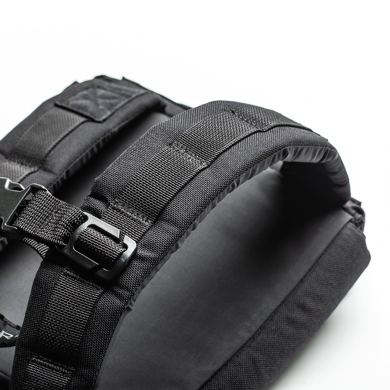 Close-up of black padded backpack straps with buckle on a white background, designed for weighted training with the RPC 3.0 + 10lb Ruck Sandplate.