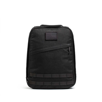The Radio Ruck USA Throwback backpack features a muted American flag patch, front zipper pocket, horizontal webbing accents, and a bombproof laptop compartment inspired by Special Forces durability.