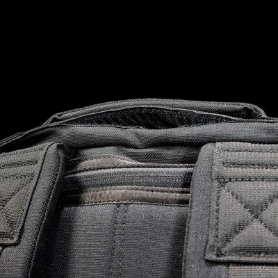 Close-up of the Radio Ruck USA Throwback, a black tactical-inspired backpack with visible stitching and padded shoulder straps, designed for durability and versatility, set against a black background.