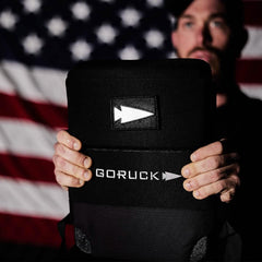 GORUCK rucksack with reflective spearhead patch held in front of American flag