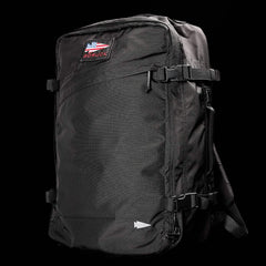 Black GORUCK rugged rucksack with American flag patch and compression straps against black background
