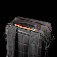 GORUCK rugged black rucksack with padded back and orange interior, showcasing durable shoulder straps and upper zipper