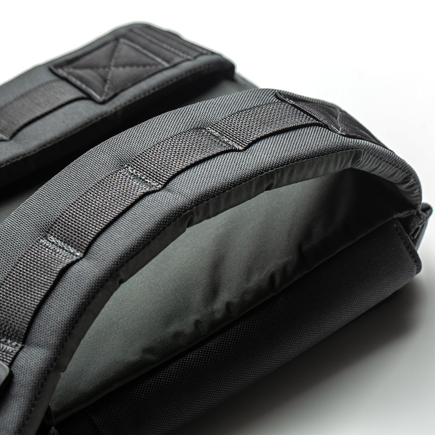 Close-up of black padded backpack straps with visible stitching on a light background, designed for use with the RPC 3.0 + 10lb Ruck Sandplate in weighted training.