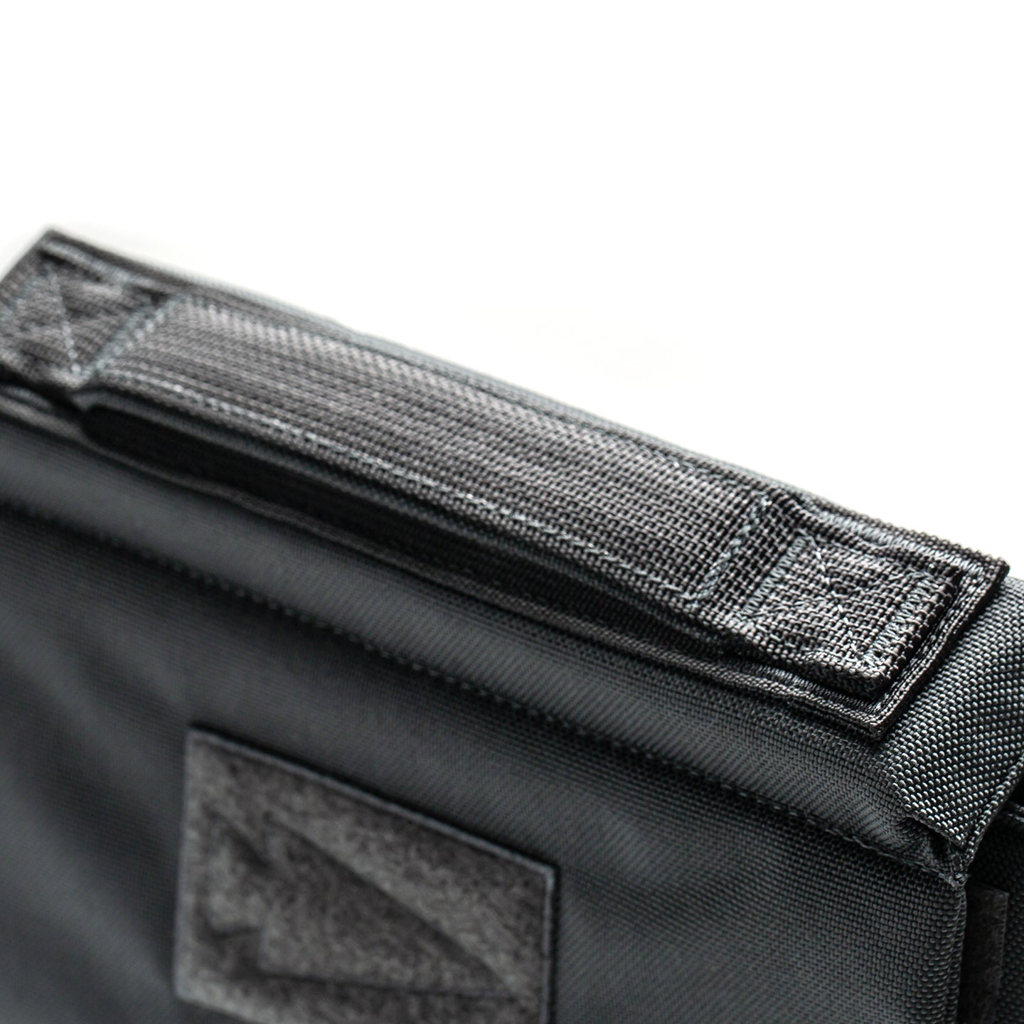 Close-up of a black RPC 3.0 + 10lb Ruck Sandplate bag with a textured handle and Velcro patch, designed to complement your weighted training vest or Ruck Plate Carrier.
