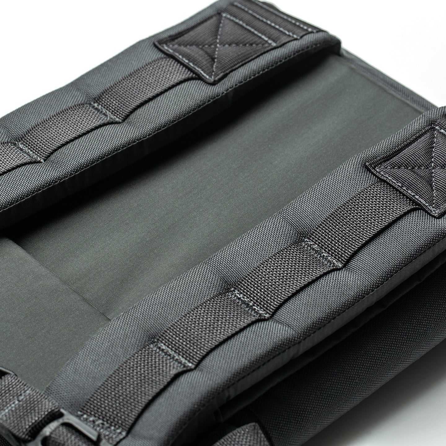 Close-up of padded, dark gray shoulder straps and stitching on the RPC 3.0 + 10lb Ruck Sandplate backpack against a white background.