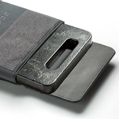 A black RPC 3.0 + 10lb Ruck Sandplate is partially inserted into an open gray pouch, ready for use with a Ruck Plate Carrier or weighted training vest.