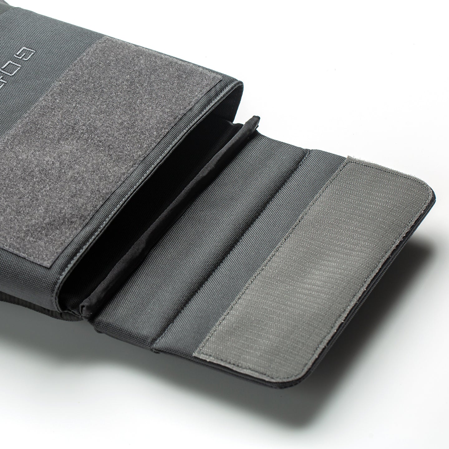 A close-up of an open gray pouch with multiple compartments, ideal for organizing gear such as the RPC 3.0 + 10lb Ruck Sandplate, set against a white background.