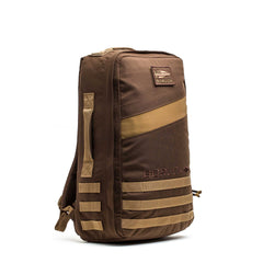 The Rucker 4.0 is a brown and tan tactical backpack with multiple straps, a side handle, and a front GORUCK logo patch—designed as a rugged rucking bag for your next adventure.