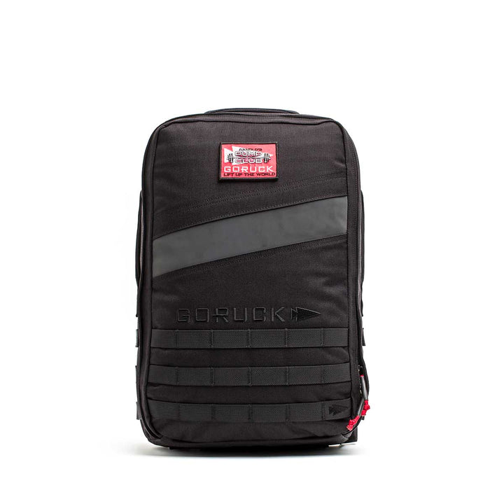 The 20L Rucker 4.0 - GORUCK x Arnold’s Pump Club features a black design, red and white patch, front zipper, and horizontal webbing—perfect for rucking or carrying your Arnold’s Pump Club essentials.