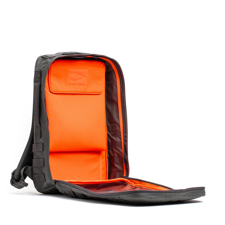 The Rucker 4.0 is a black rucksack with a fully unzipped front that reveals a bright orange interior and multiple compartments—ideal for training, rucking, or keeping your gear organized wherever you go.
