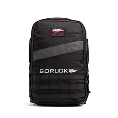 A black Rucker 4.0 backpack with a U.S. flag patch, white GORUCK logo on the front, and built tough for rucking or carrying Ruck Plates.