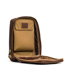 The Rucker 4.0 backpack stands upright with its main compartment unzipped, revealing a tan interior pocket—ideal for carrying Ruck Plates on your next rucking adventure.