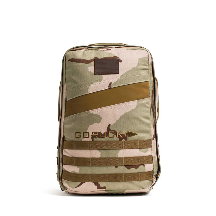 The Rucker 4.0 is a tan and brown camo backpack with "GORUCK" text on the front, made for rucking and Ruck Plate compatible, displayed on a white background.