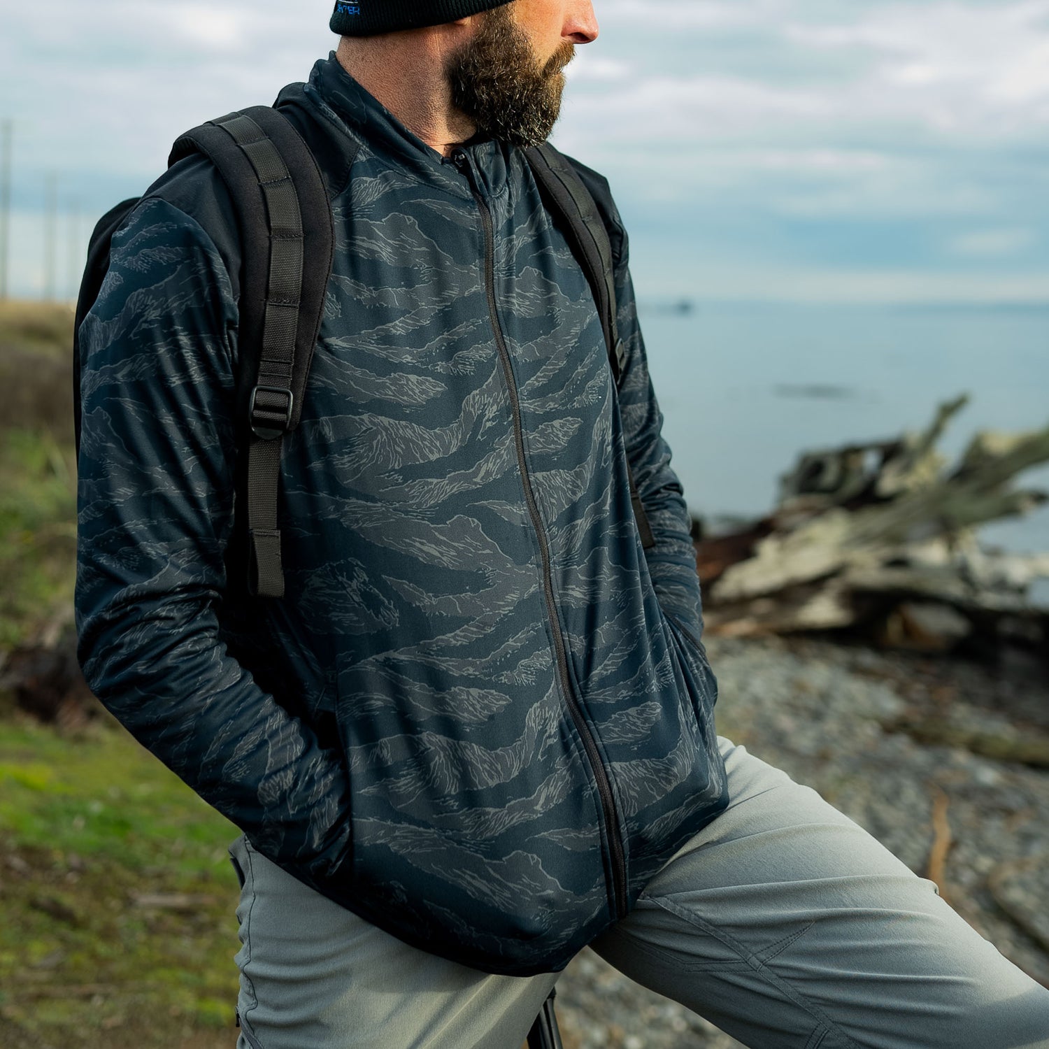 Man wearing GORUCK rucking jacket and backpack outdoors by the water
