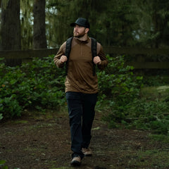 Man rucking with GORUCK backpack in forest, outdoor training gear, rugged trail setting