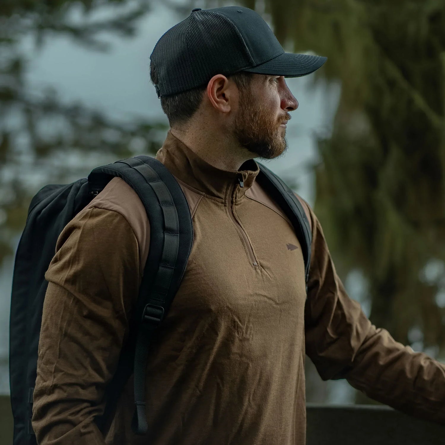 Man wearing GORUCK rucking gear and black backpack outdoors in forest setting