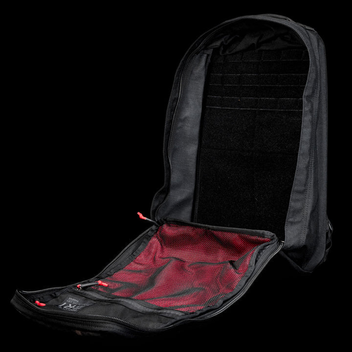 The GR1 Shooter 26L - Built by SCARS backpack is fully unzipped, showing a red mesh interior pocket and organized compartments—rugged enough for any adventure, just like every Shooter Ruck tested by the SCARS team.